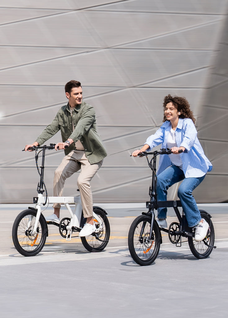 a man rides a white engwe p20 and a woman rides a black engwe p20 city e-bike on the road