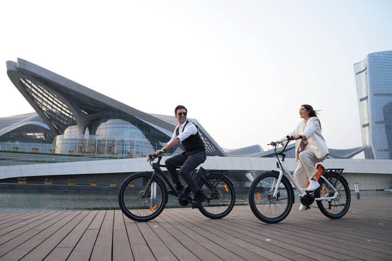 a gentleman and a lady respectively riding 2 engwe p275 e-bikes