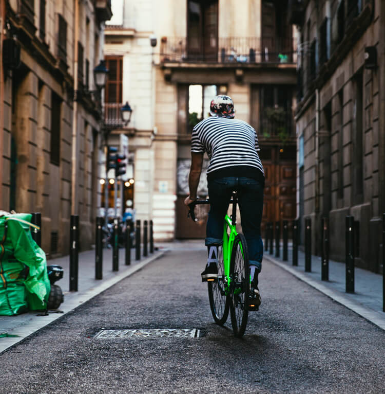 a man wearing a helmet rides a green e-bike on the road