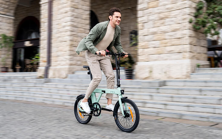 a man riding an engwe p20 mini e bike on the street