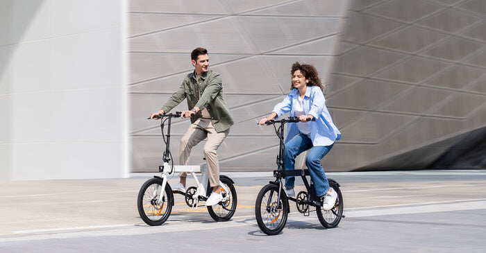 a man and a woman ride a black and white engwe p20 commuter bikes