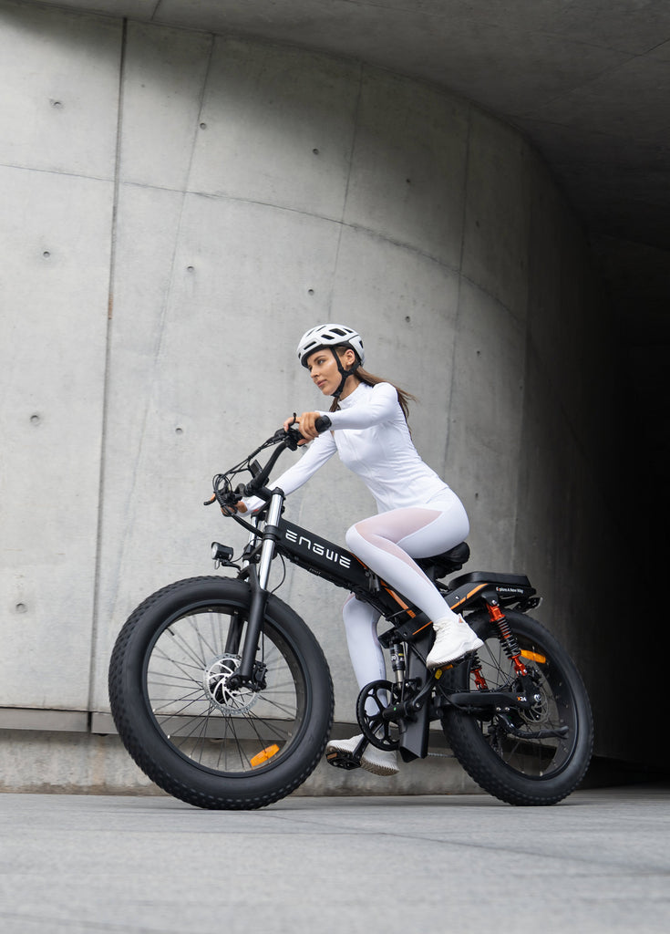 a woman rides a black engwe x24 fat tire electric bike